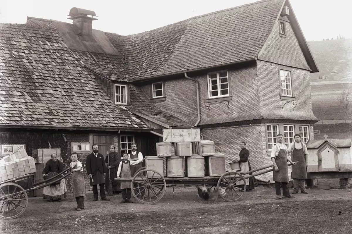 Historische Szene mit Menschen und Karren vor Fachwerkhaus