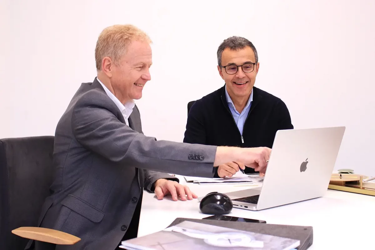 Zwei Männer diskutieren am Laptop im Büro