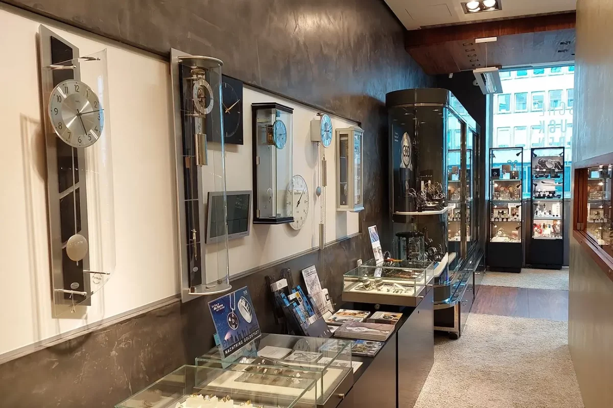 Innenraum eines Schmuck- und Uhrenladens mit Vitrinen und Wanduhren