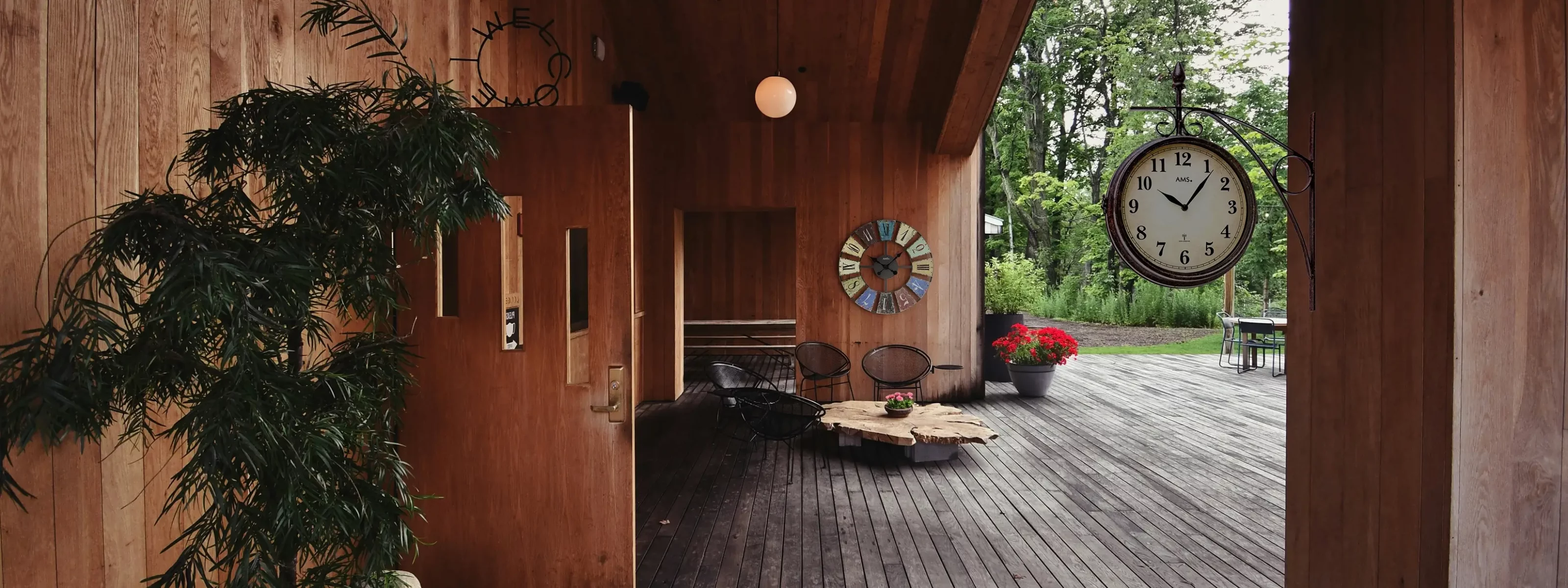Moderne Holzterrasse mit Pflanzen und Wanduhr im Freien