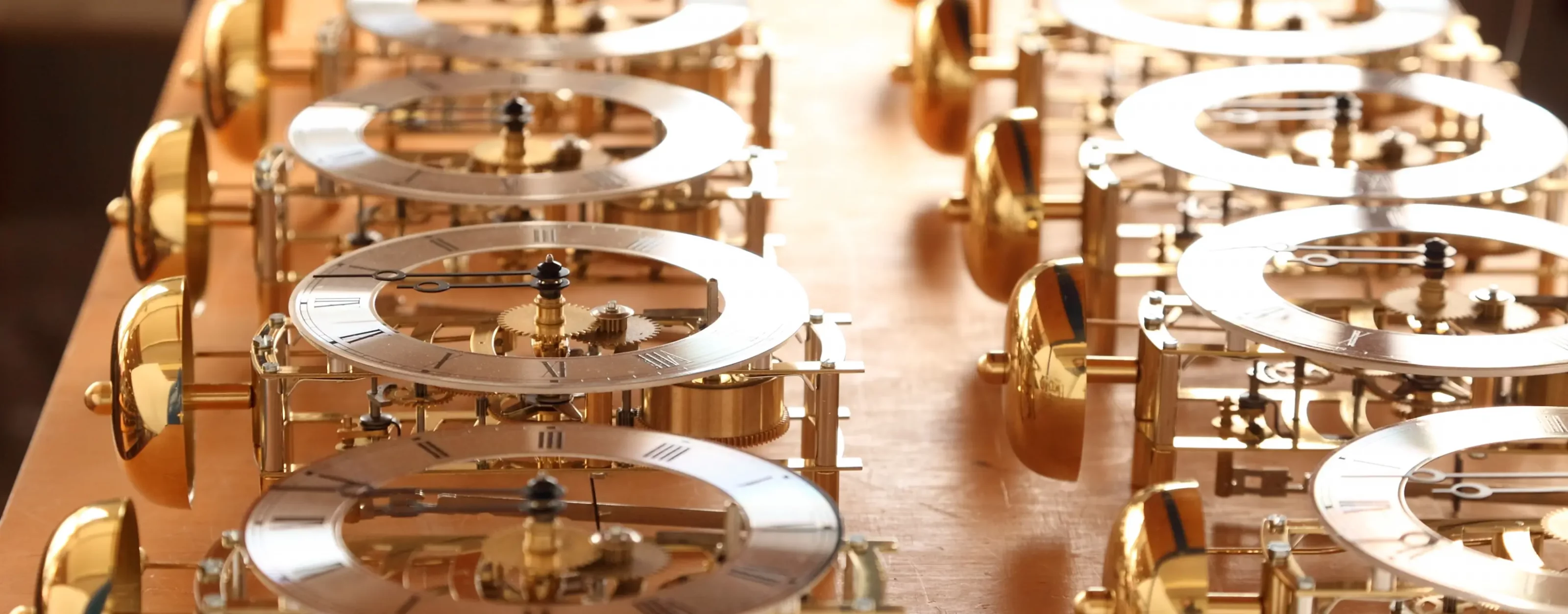 Nahaufnahme antiker Uhrenzahnräder aus Messing auf Holz