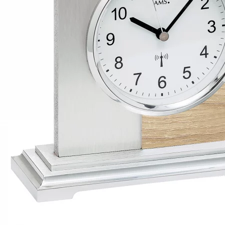 Detailaufnahme einer modernen Tischuhr mit silbernem und holzfarbenem Gehäuse