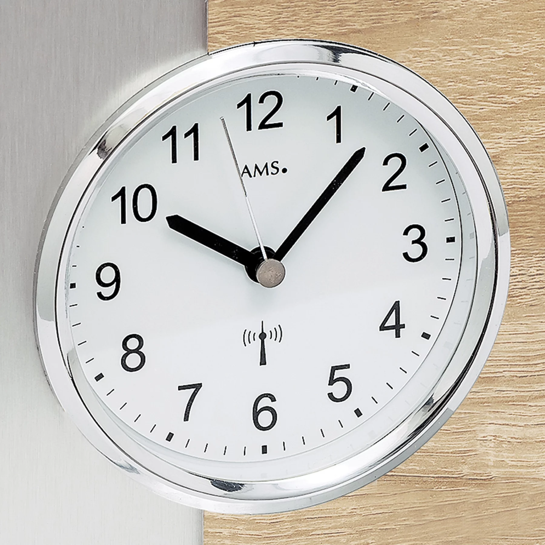 Runde Funkuhr mit silbernem Rahmen und weißem Zifferblatt