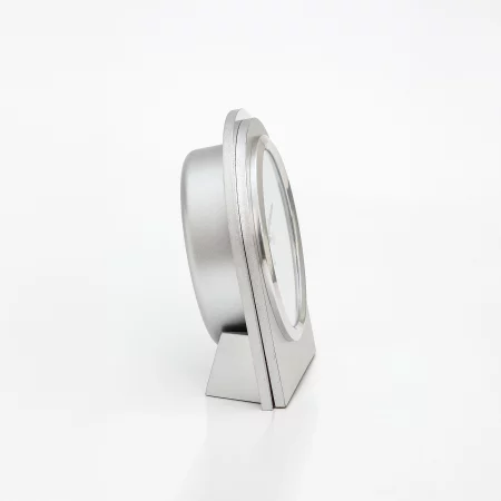 Silberne Tischuhr im seitlichen Profil vor weißem Hintergrund