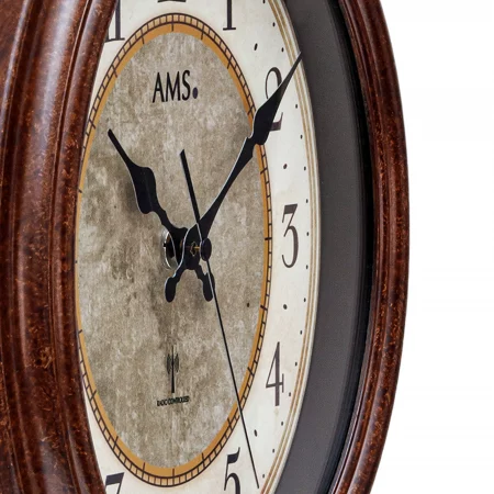 Nahaufnahme einer braunen Wanduhr mit römischen Ziffern und AMS-Logo