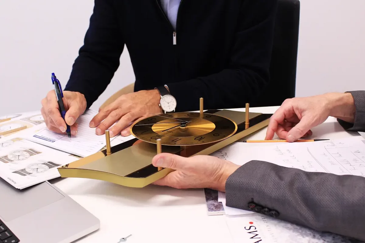 Zwei Männer entwerfen ein Uhrendesign am Schreibtisch