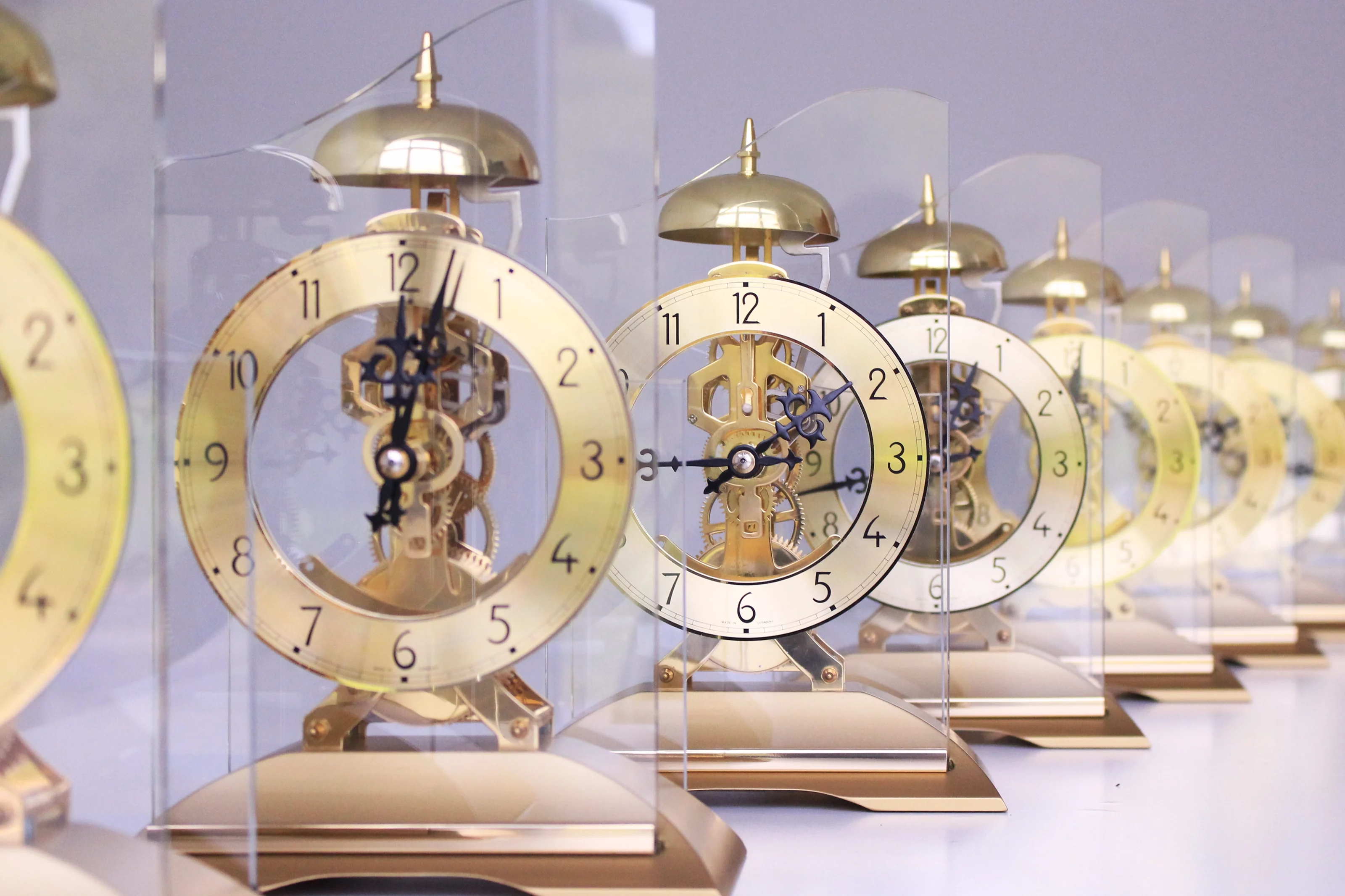 Reihe goldener Glasuhren mit sichtbaren Mechanismen