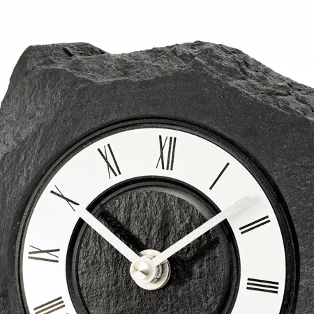 Uhr mit römischen Ziffern in schwarzen Gestein