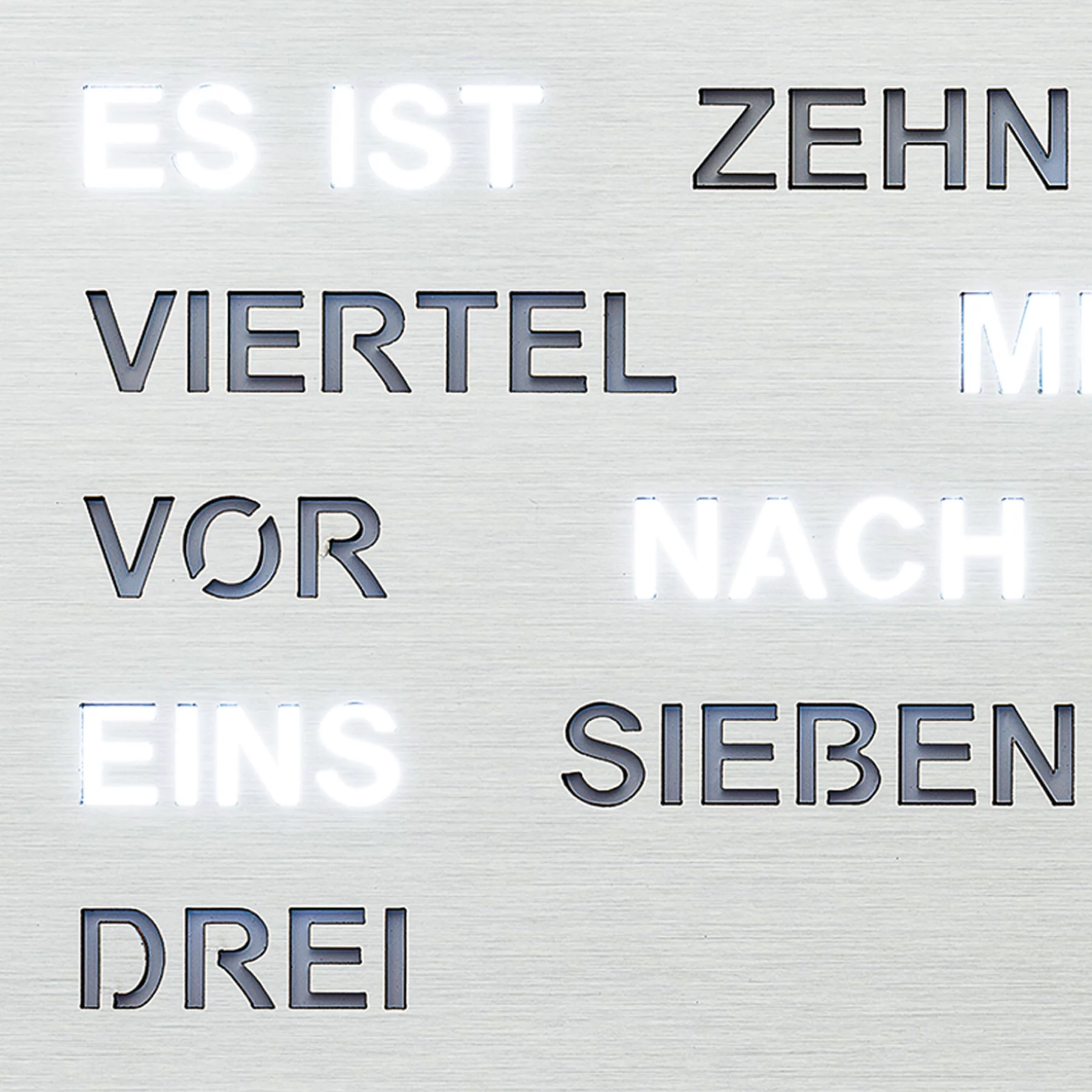 Moderne Wanduhr mit leuchtenden Wortanzeigen aus Edelstahl