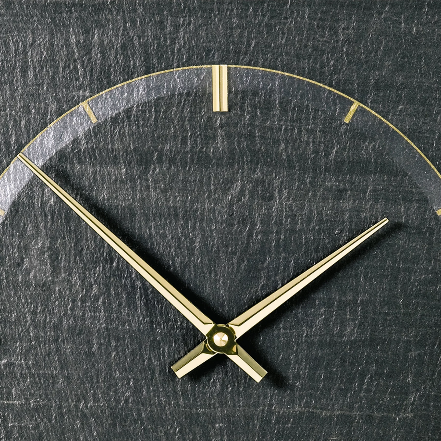 Goldene Uhrzeiger auf grauem Zifferblatt aus Schiefer
