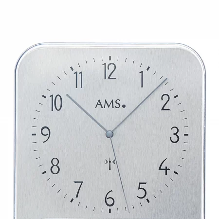 Silberfarbene analoge Wanduhr mit schwarzen Ziffern auf weißem Zifferblatt